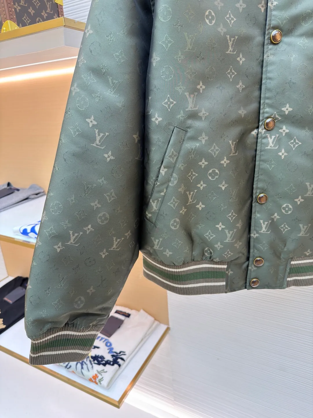 LOUIS VUITTON striped trim jacquard long-sleeved bomber jacket ●Original version: purchased and developed by 29237 ●Item number: 1682087-C05 ●Fabric: nylon fabric ●Technology: jacquard production ●Color: green ●Version: fitted version ●Weight: about 800 grams ●Size: S-M-L-XL ●Description: This Louis Vuitton baseball jacket is made of high-density jacquard satin fabric. The base is a polyester fiber blended material with a military green matte texture. The classic Monogram presbyopia pattern is woven into the fabric in the form of dark patterns of the same color through a special weaving process. The pattern texture is three-dimensional and presents a delicate illusion luster with the angle of light. High-precision jacquard weaving technology is used in the process to ensure the integrity and delicacy of the pattern. The body adopts a single-row metal snap closure design. The metal buckles are matte and distressed to echo the color of the body. The ribbed collar, cuffs and hem are made of two-color knitting technology. The elastic ribs have both stiffness and comfort, and are pre-shrunk to prevent deformation. The overall cut is a loose oversize version, and the splicing uses a combination of flat seams and hemming techniques. The interior is supplemented by smooth overlock sewing. Every stitch is even and fine, which fully reflects the brand's exquisite garment production technology and detail control. The overall wiring is straight and delicate, the fabric is comfortable and soft, and the color is consistent without color difference. It can be matched with the same style to create a fashionable look and control various occasions. Customized accessories, complete with three standards, same style for men and women!